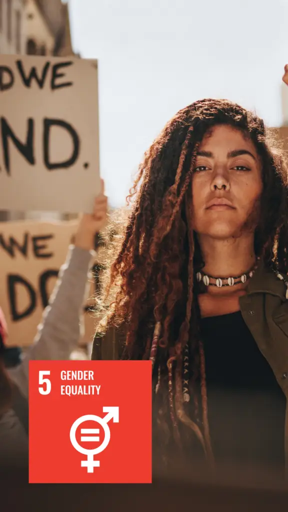 Individual participating in a gender equality demonstration, with a logo in the corner representing the fifth Sustainable Development Goal by the United Nations, Gender Equality.